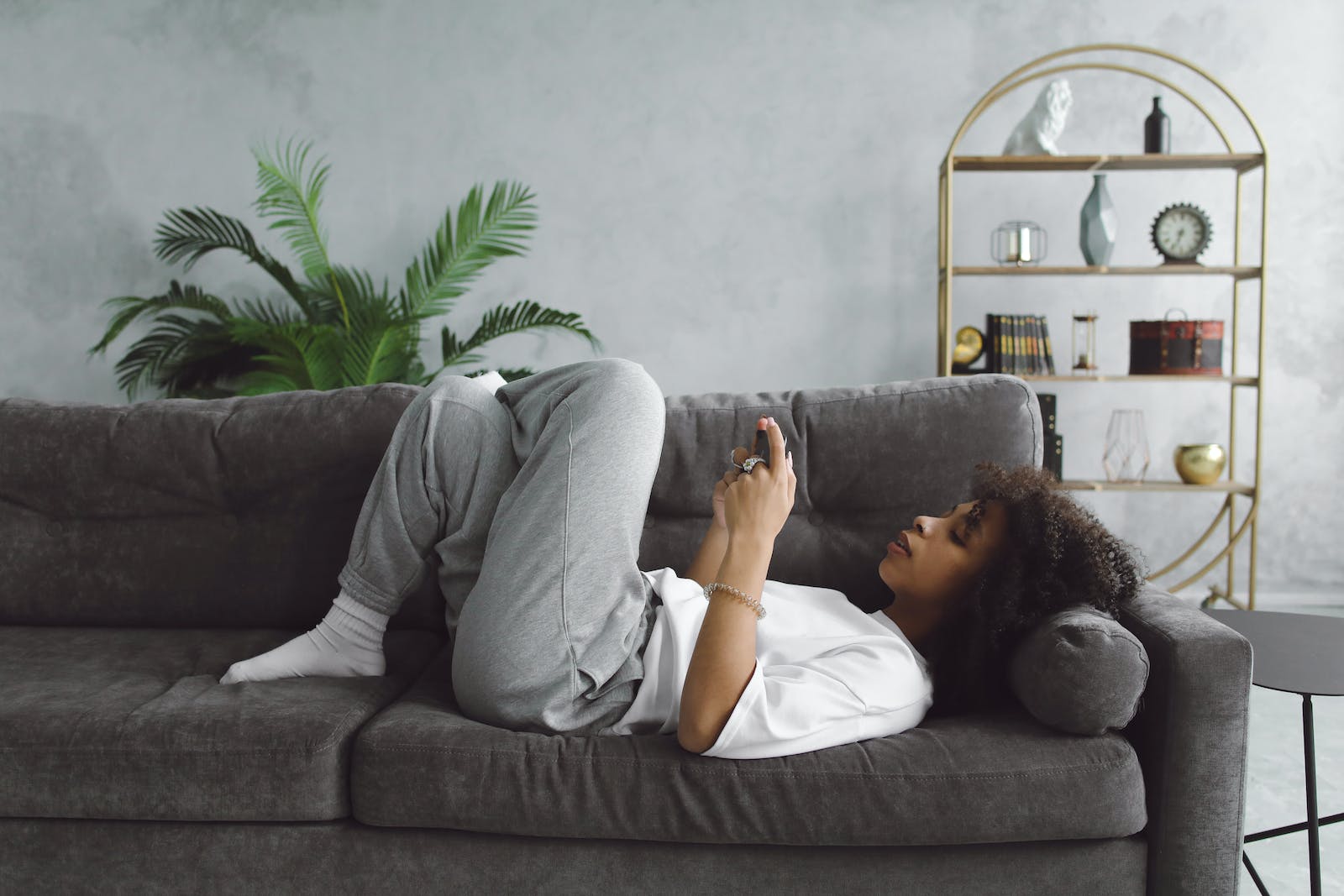 femme allongée sur un sofa utilisant un cellulaire